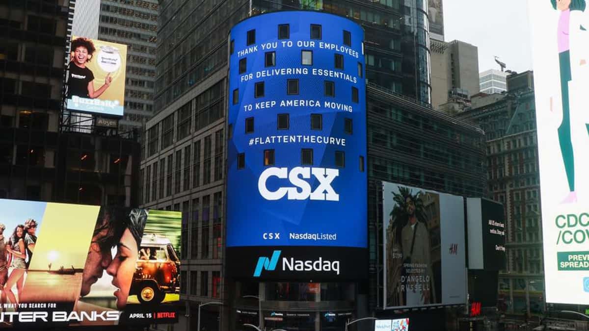 A photograph of CSX's logo on a large outdoor screen in the middle of a city intersection.