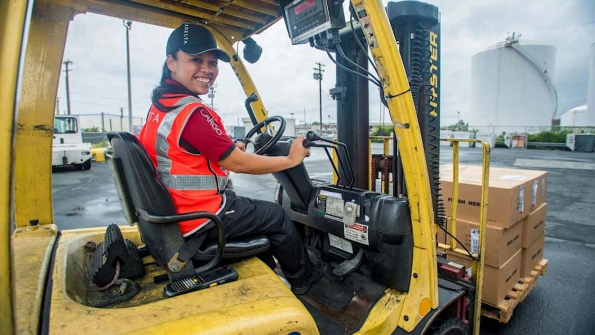 Delta Air Lines cargo worker driving a forklift.