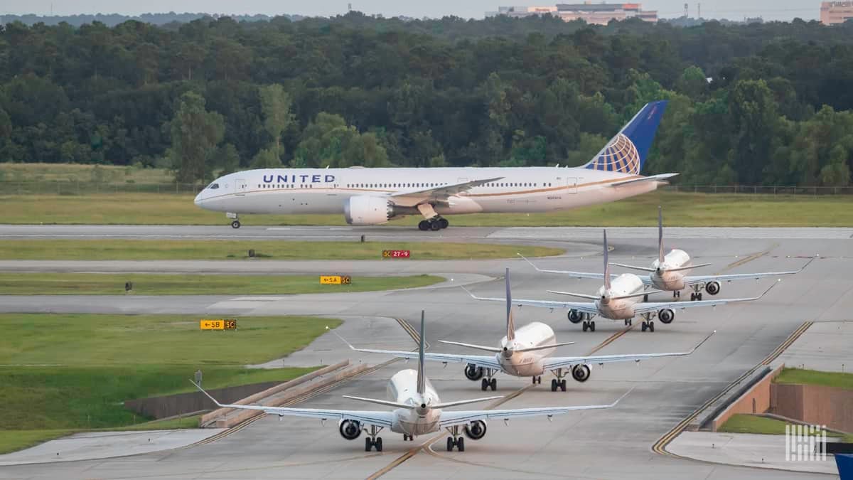 United Airlines jets line up along taxiway to take off at Houston airport. United is increasing its international schedule.