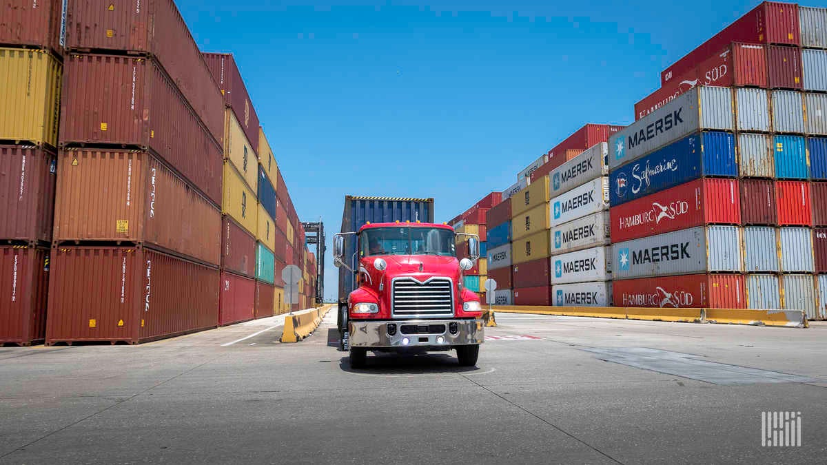 Red drayage truck loading container at port