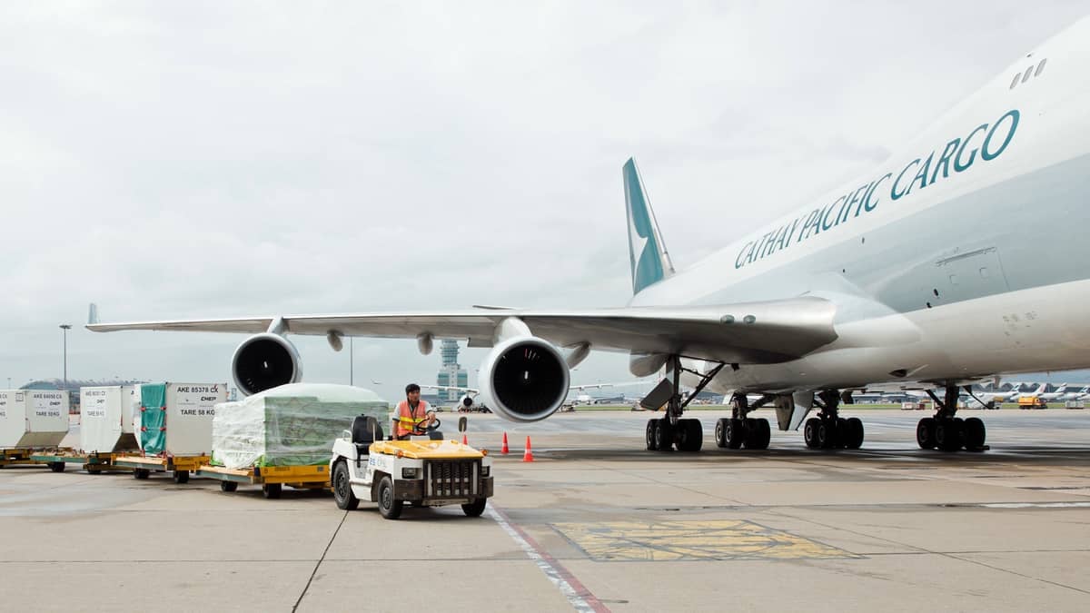 A cargo tug drops off a load next to a Cathay Pacific jet. The air cargo business in June was down a fifth from last year's level.