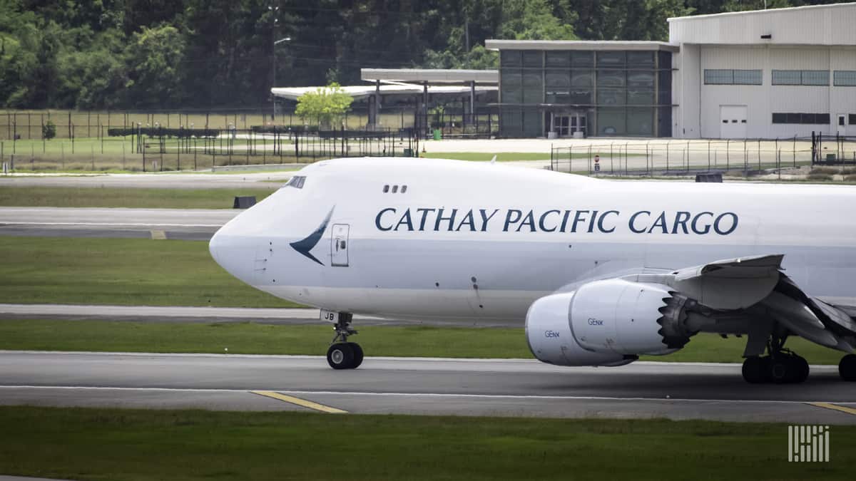 A white Cathay Pacific jumbo jet gets ready to takeoff. Cathay Pacific is bolstering its cargo team with new additions.