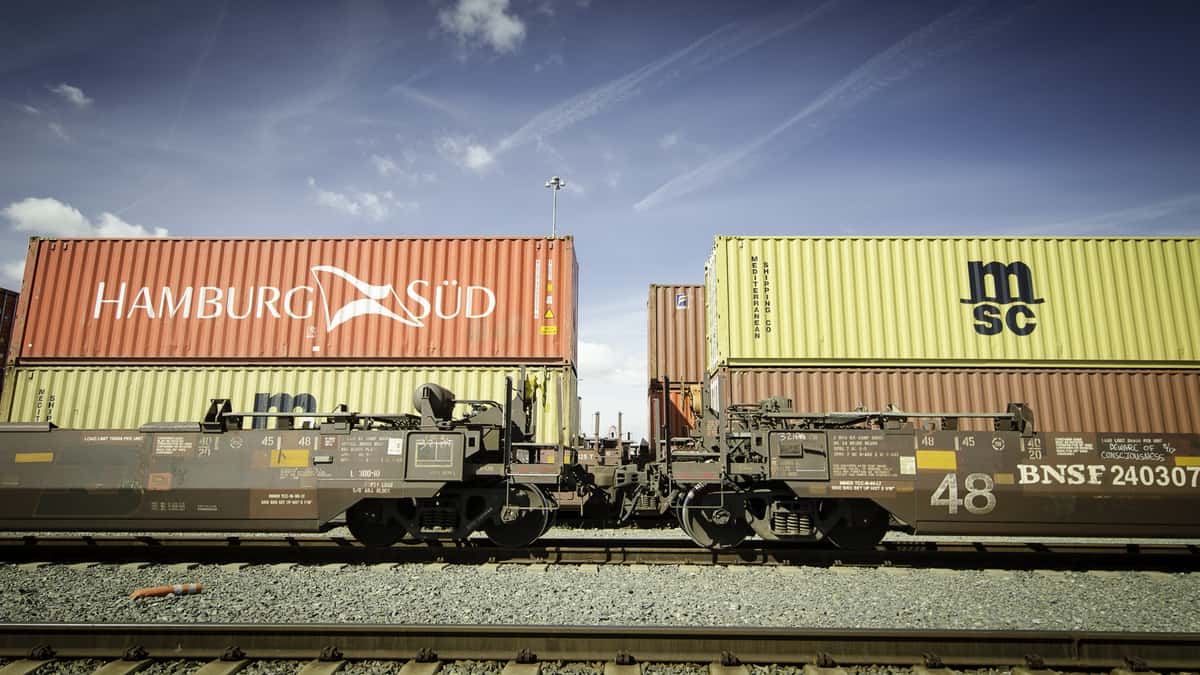 A photograph of a double-stacked intermodal train parked at a rail yard.