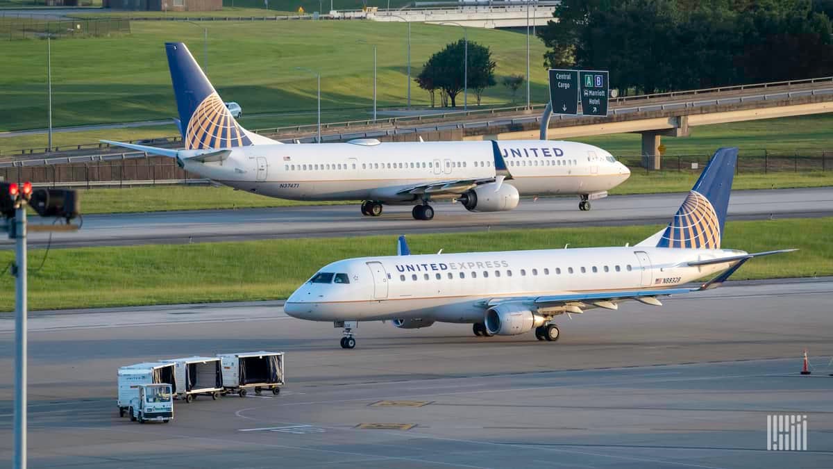 White jets with blue tails pass each other at Houston's main airport.