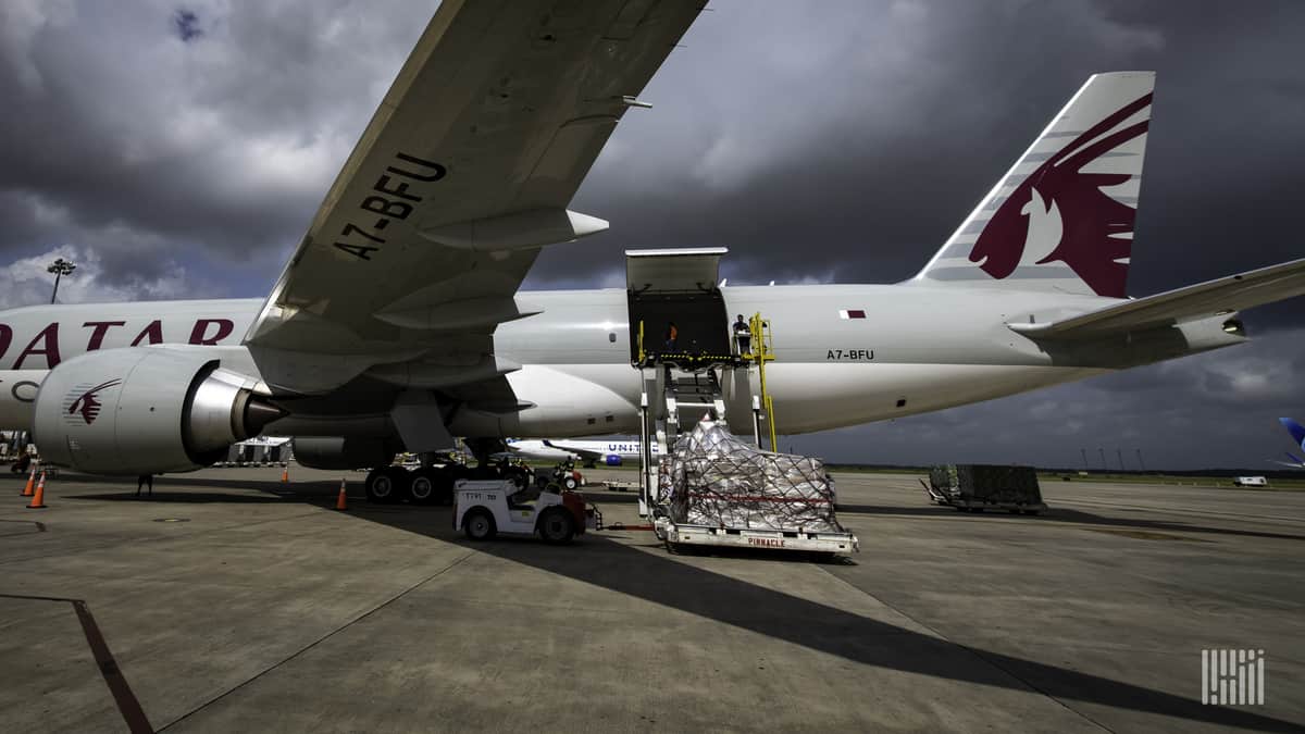 A large jet gets loaded with pallets of cargo under a cloudy sky. Air cargo security rules are tightening in the next year.