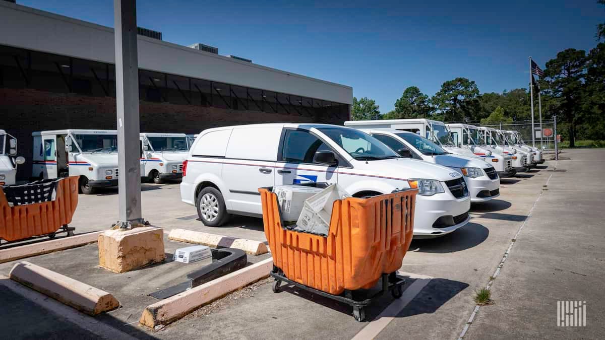 A U.S. Postal Service (USPS) delivery van in a parking lot. The USPS online tracking service was restored after an outage hit customers.