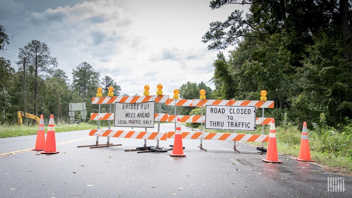 "Road Closed" barrier across a highway.