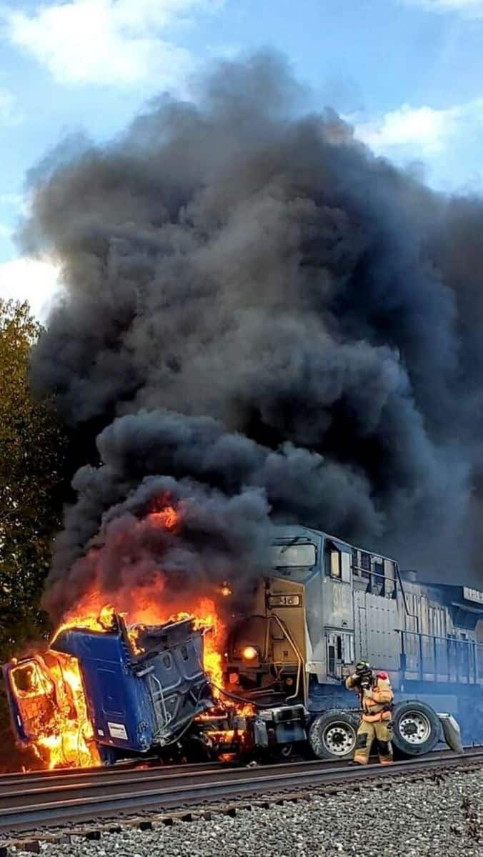 Truck on fire after train slams into it.