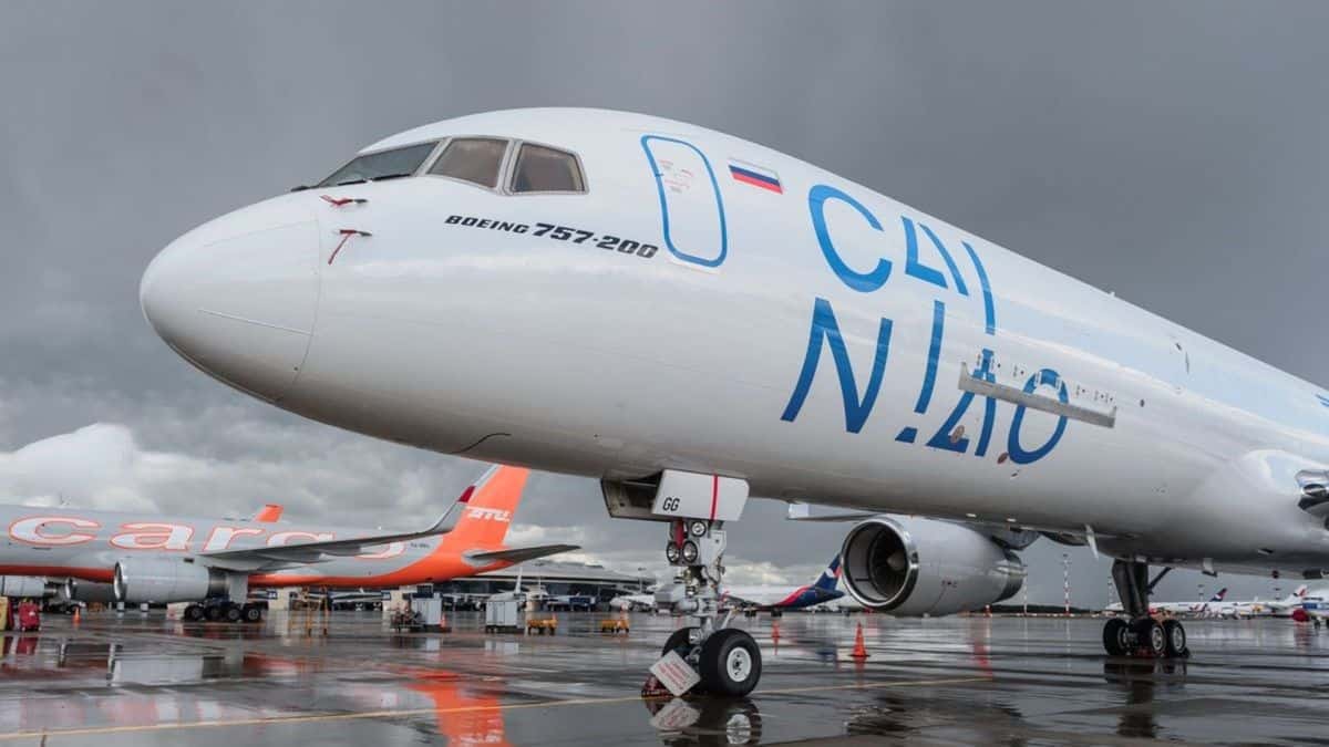 A white jet parked at airport, viewing from ground to the side and below the cockpit.