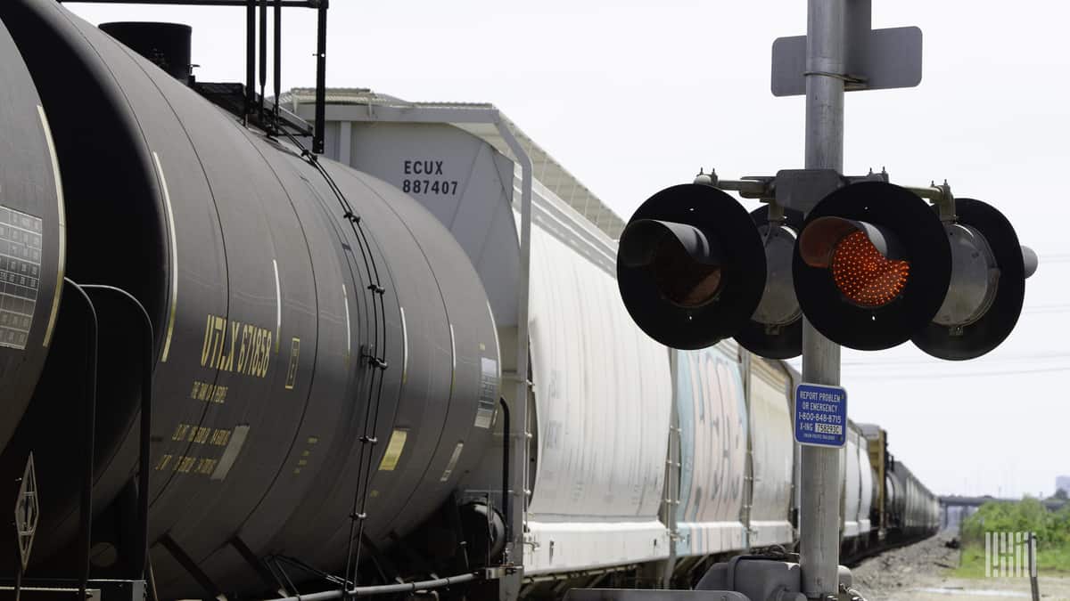 A photograph of a train passing through a railroad crossing.