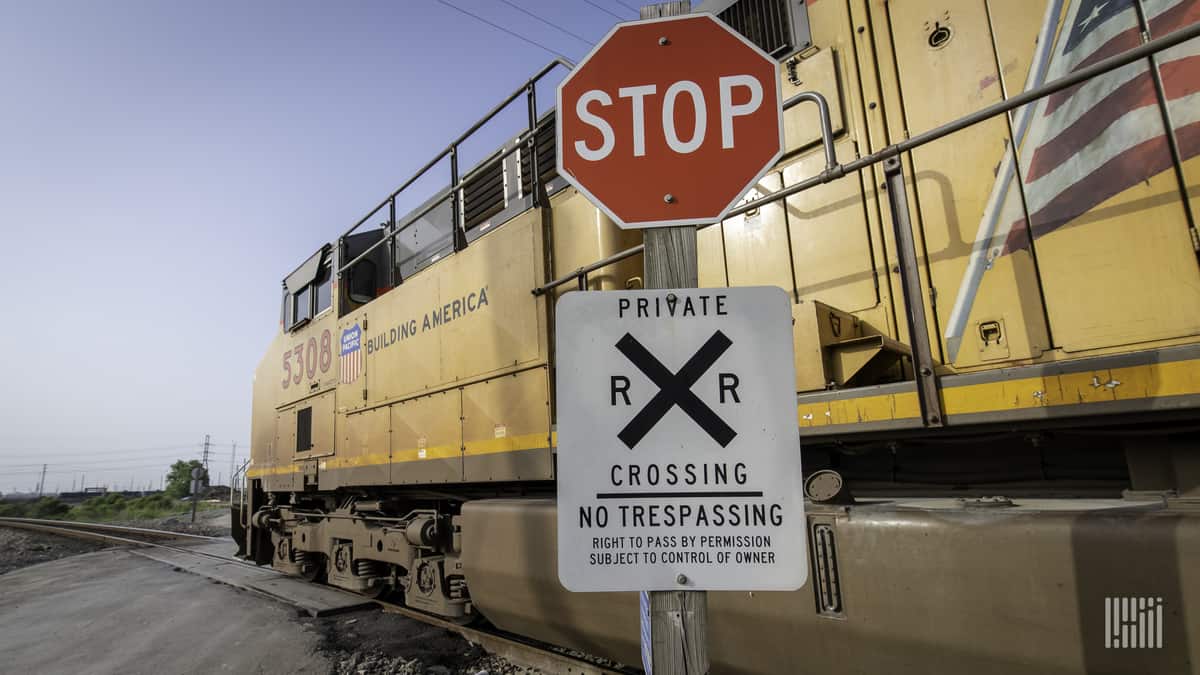 A photograph of a Union Pacific train passing by a rail crossing.