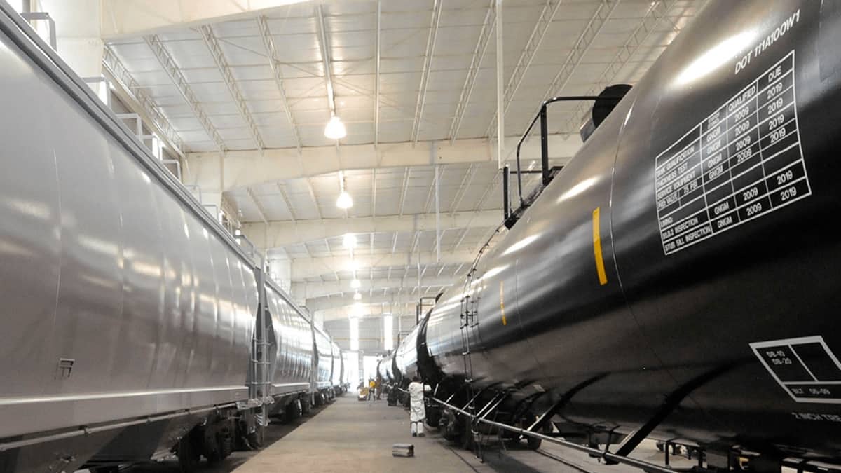 A photograph of tank cars parked inside a garage.