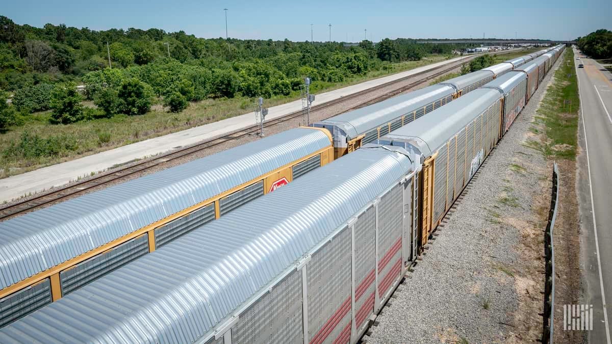 A photograph of auto railcars traveling on railroad track.