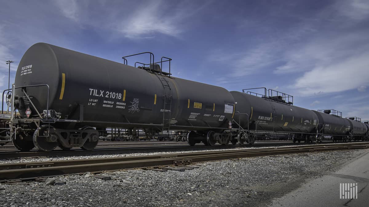 A photograph of a tank car parked in a rail yard.