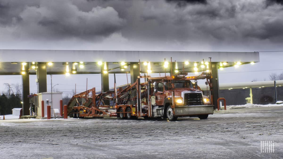 Tractor-trailer at a truck stop on a snowy day.