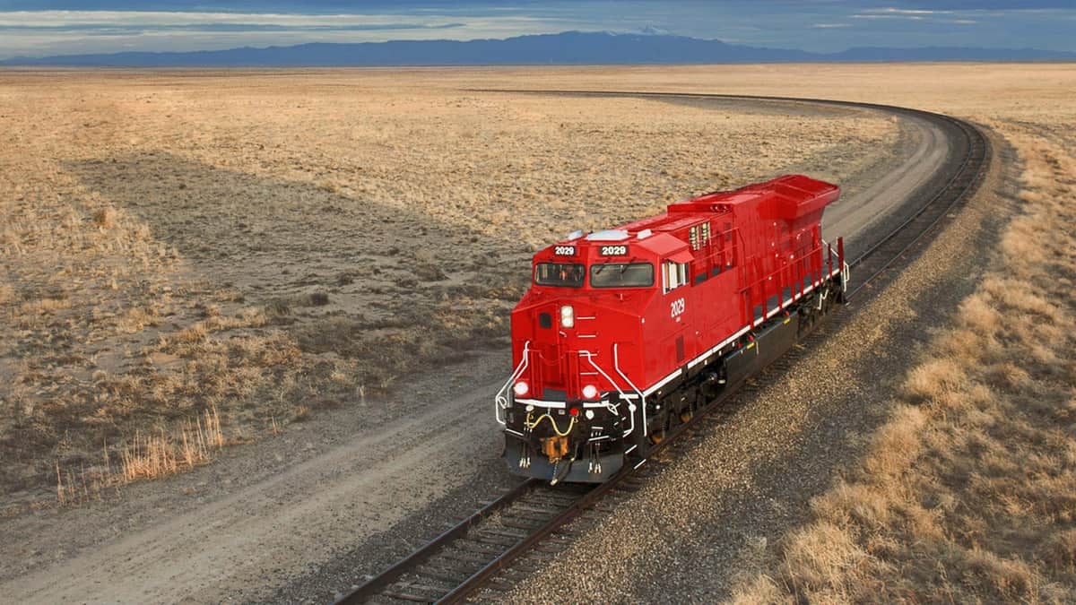 A photograph of a locomotive traveling through a desert field.