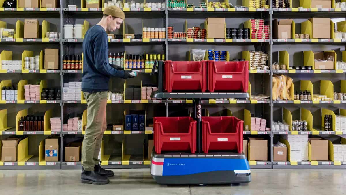 A warehouse worker with a robot from 6 River Systems. The CEO of Shopify says warehouse automation will play a key role in scaling its fulfillment network.