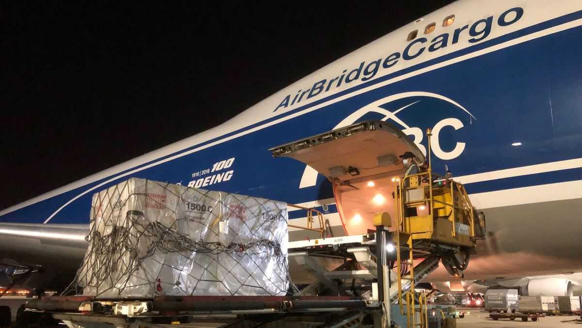 A 747 jumbo cargo plane gets loaded with large coolers containing pharmaceutical products.