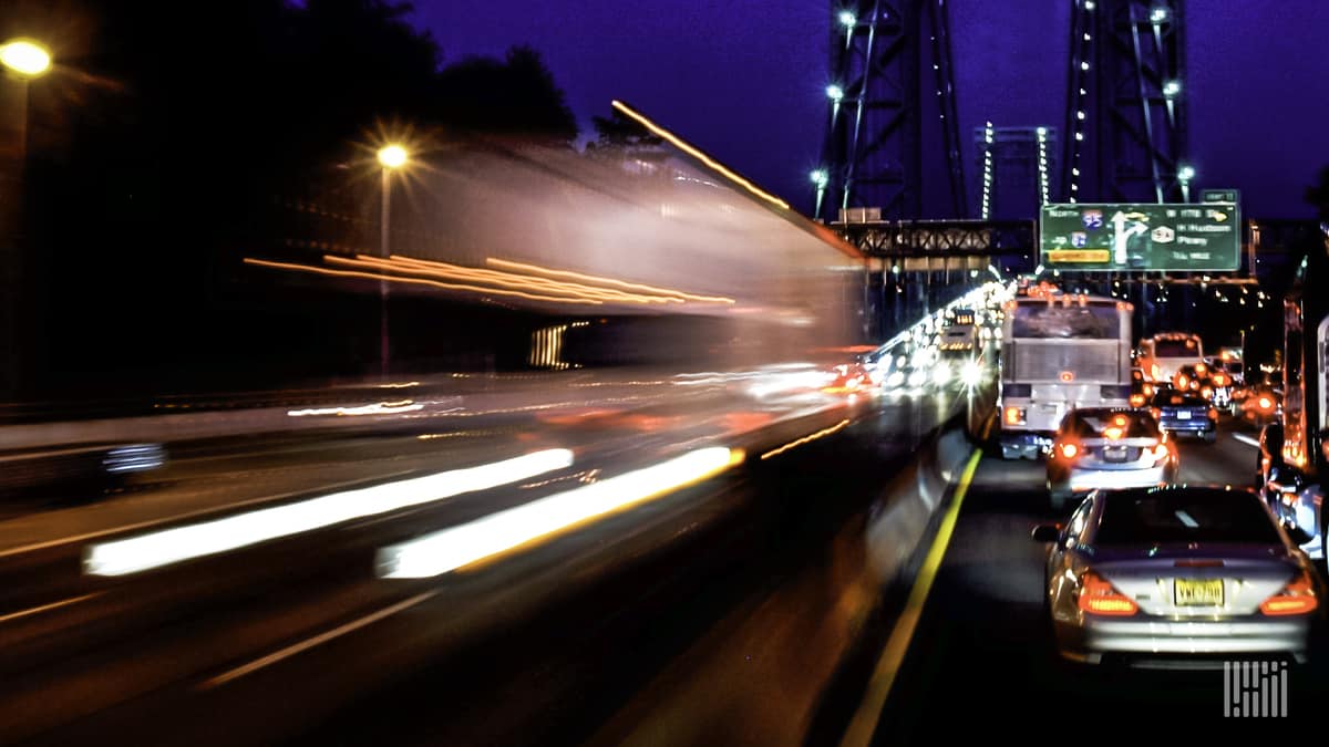 Truck driving into city at night