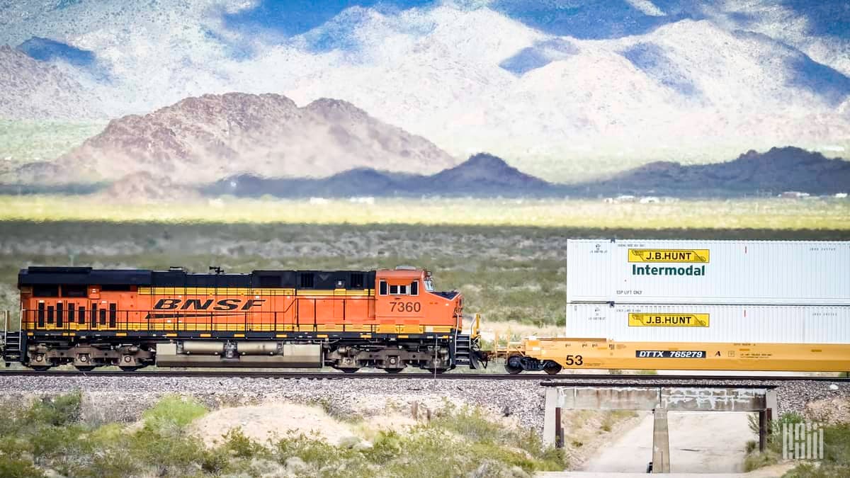 A passing flash identifies BNSF locomotive No. 7360 pulling an intermodal stack car with BNSF domestic containers across the Southwest desert. (Photo: Jim Allen/FreightWaves)