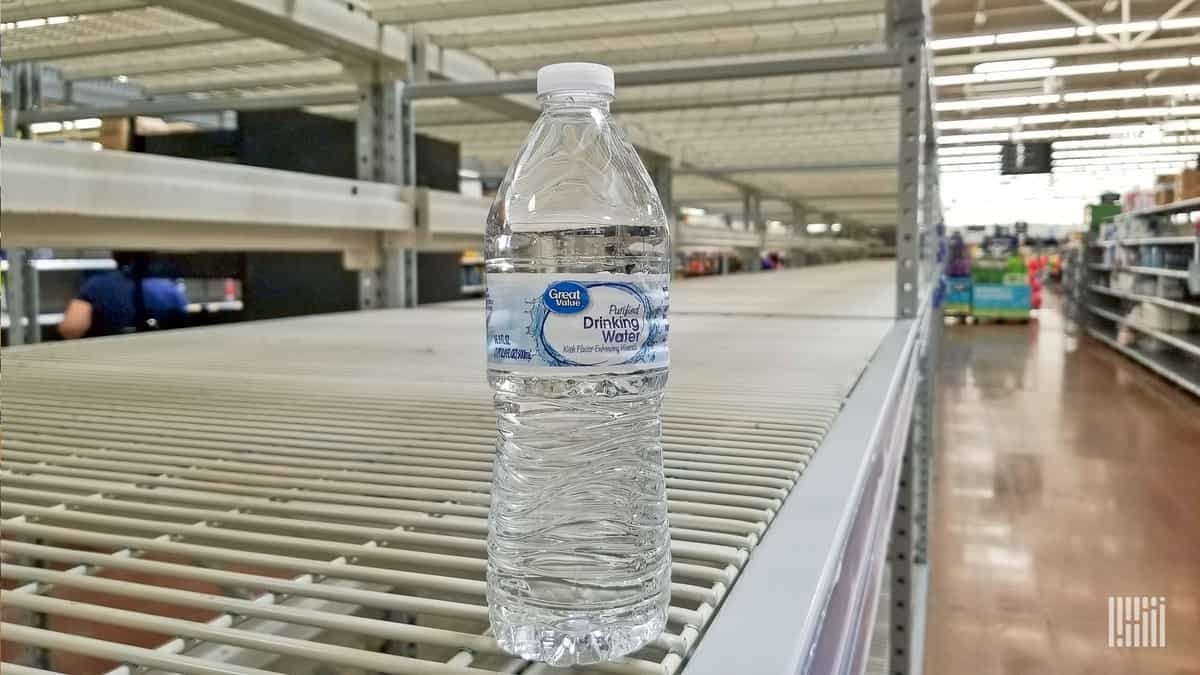 One bottle of water on an empty retail shelf