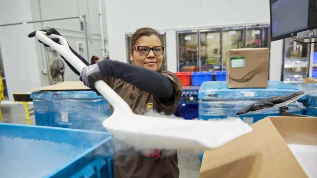 A UPS worker shovels dry ice into containers.