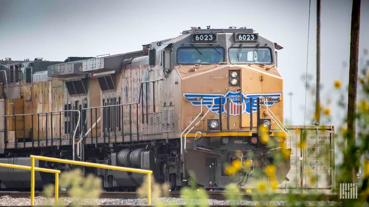 A Union Pacific train heads out of a rail yard.