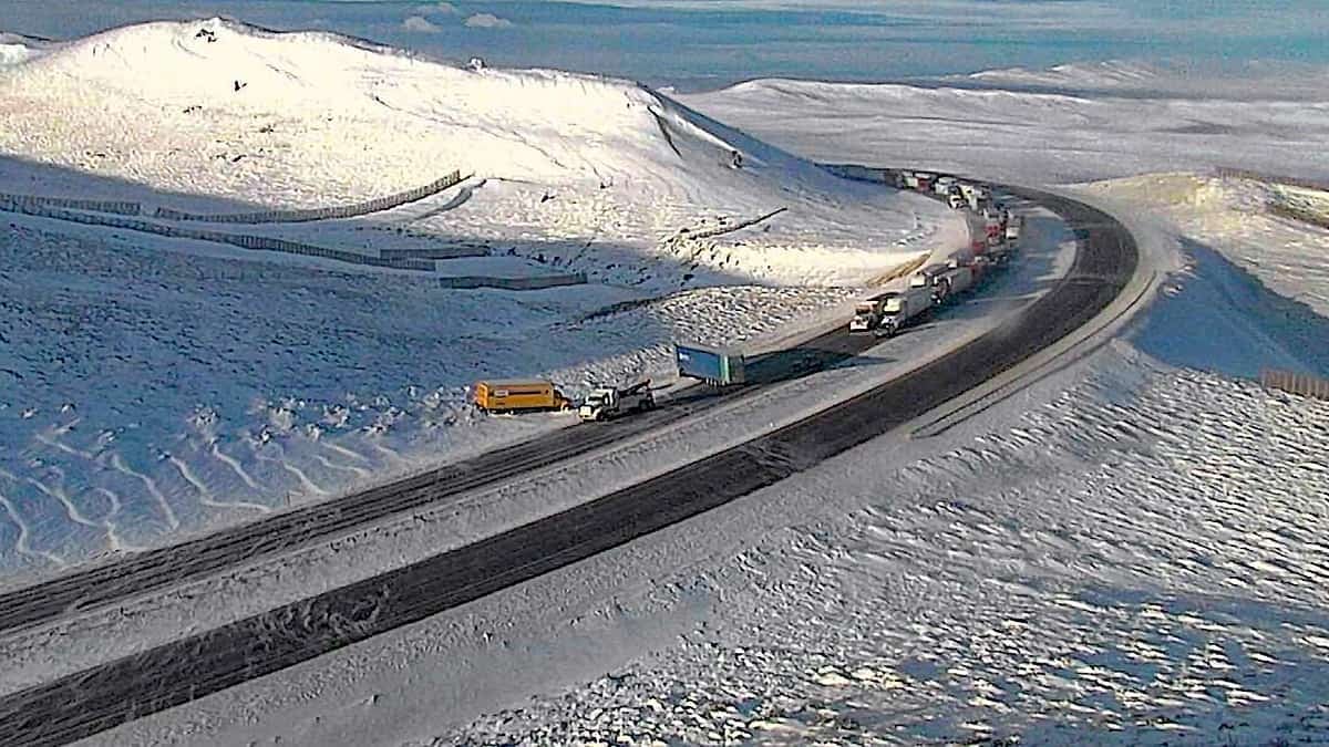 Tractor-trailers and cars on a snowy Wyoming highway.