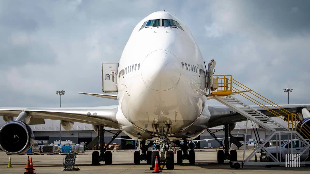 Front-end of a Boeing 747 cargo jet, looking straight on to its nose. The plane is white.