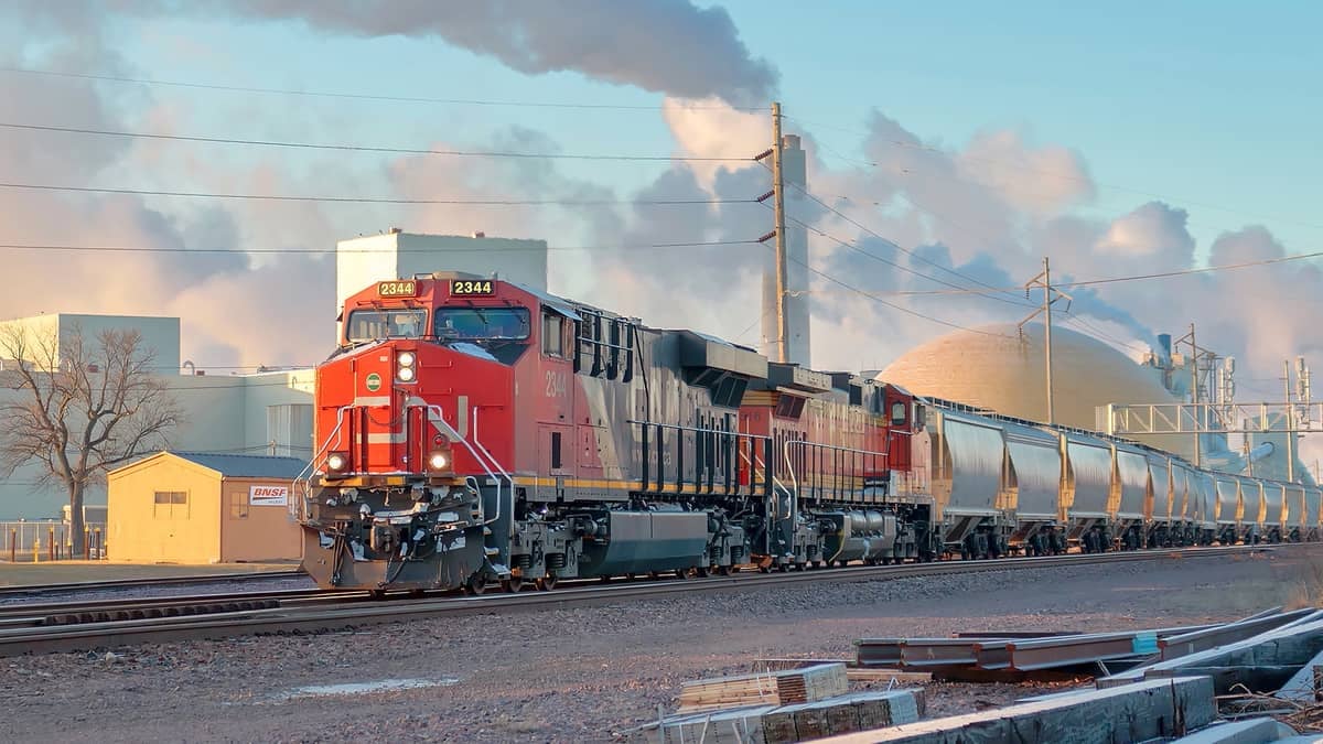 A photograph of a CN train traveling by a manufacturing facility.