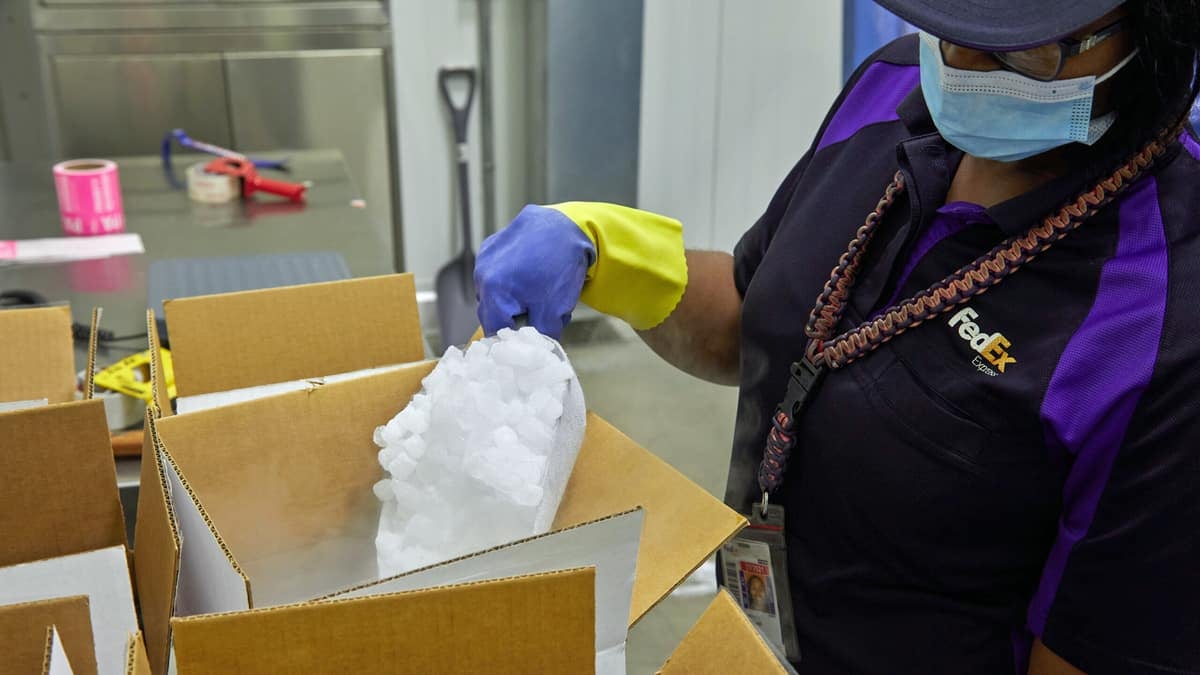 A FedEx employee packs a box with dry ice.