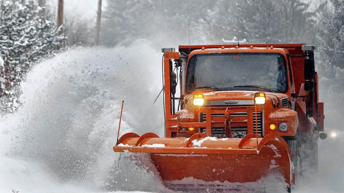 Plow truck clearing snow off a New Hampshire highway.