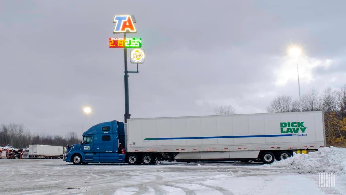 Driver entering truck stop on a snowy day.