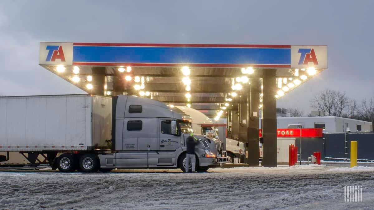 Drivers at a truck stop on a snowy day.