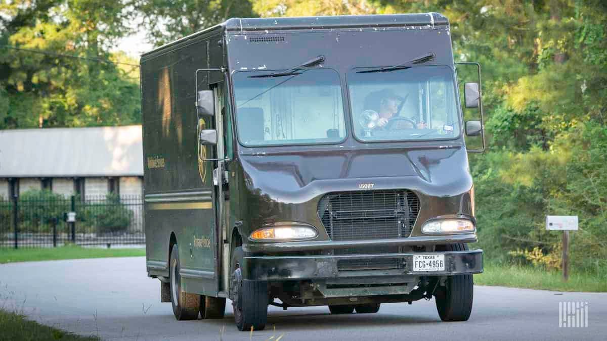 A brown UPS package car driving.