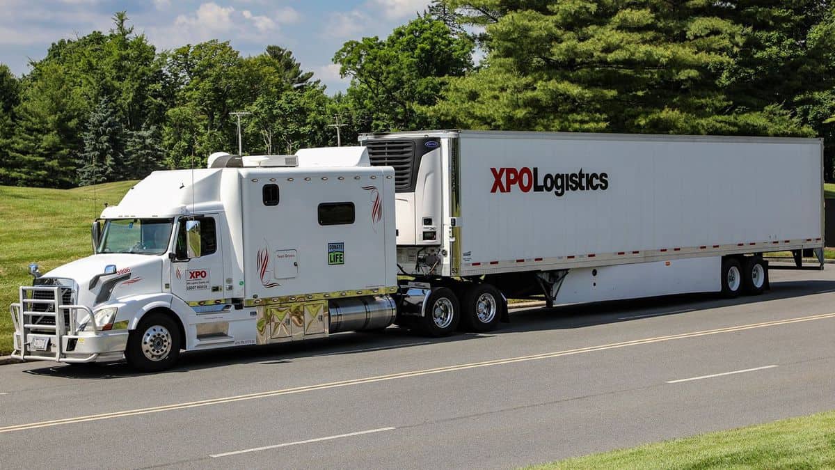 White XPO Logistics semi-trailer with sleeper cab.