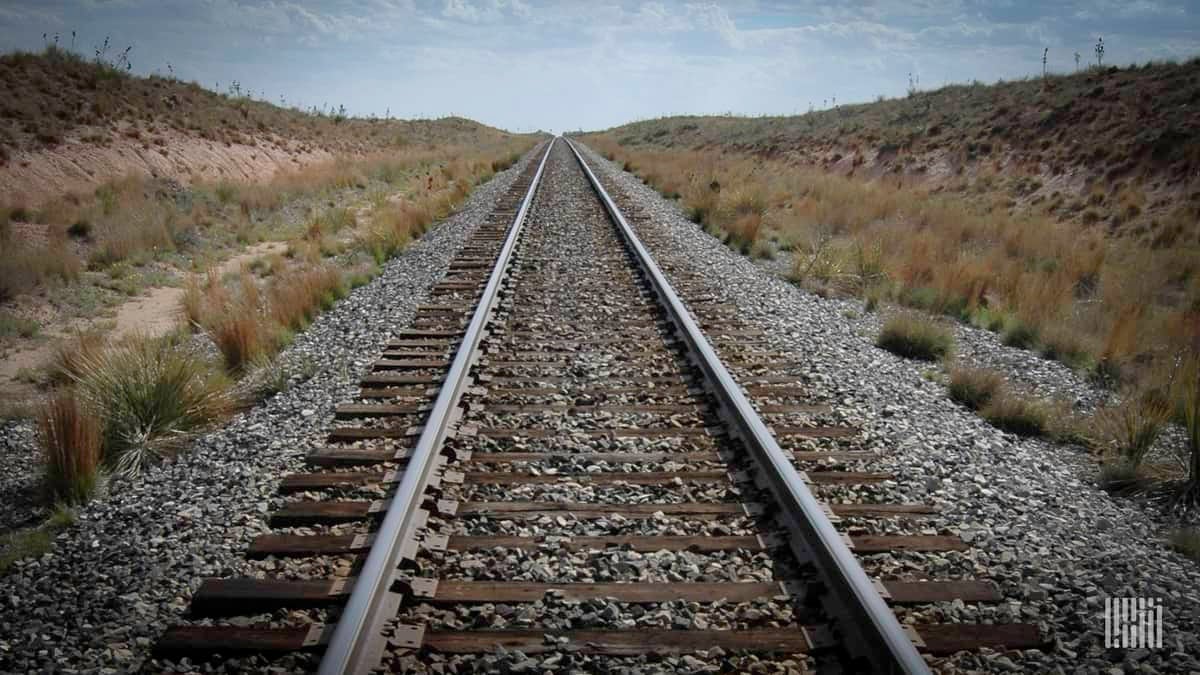 A photograph of a railroad track in a field.