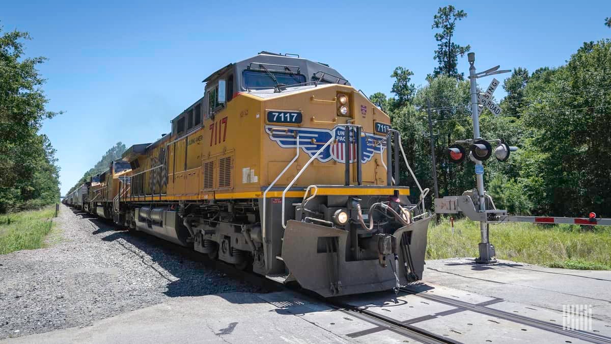 A photograph of a Union Pacific train at a rail crossing.