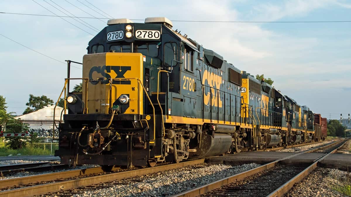 A CSX train travels down train track.