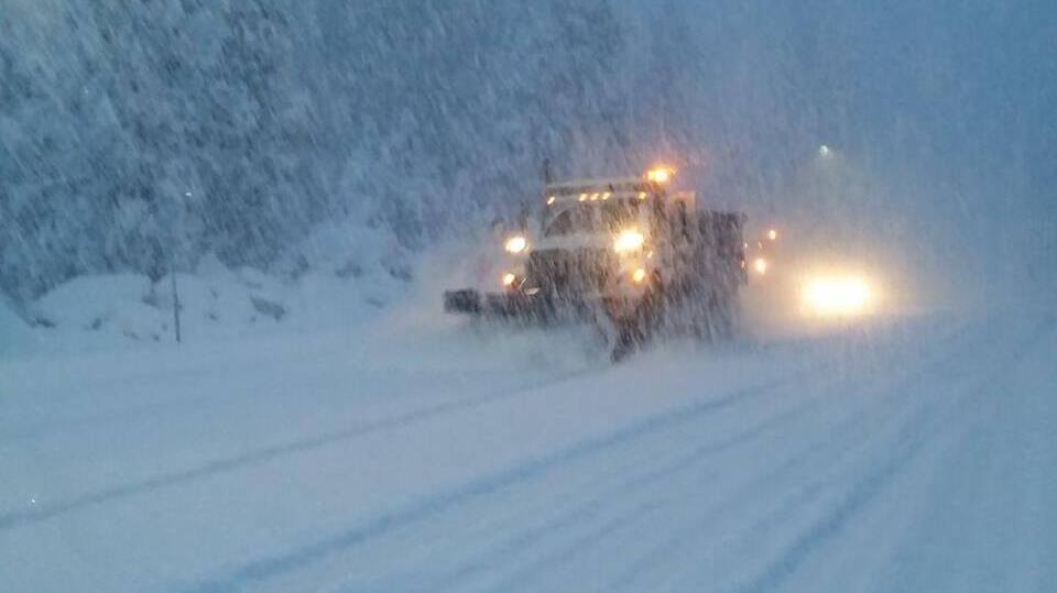 Plow truck trying to clear a snowy California highway. during a blizzard