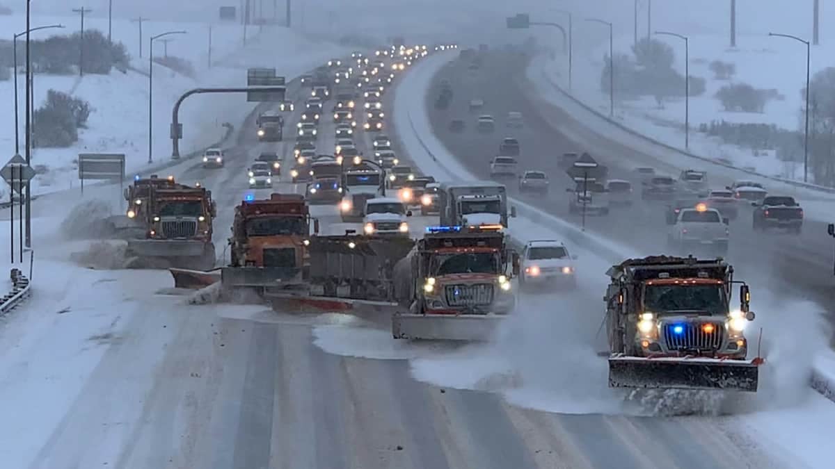 Traffic buildup behind several plows clearing a Colorado highway.