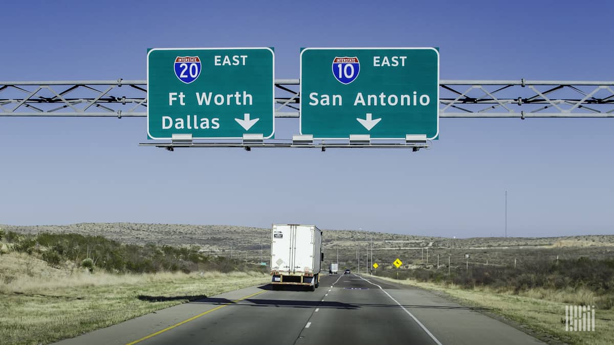 Tractor-trailer heading down I-20 in Texas on a sunny day.