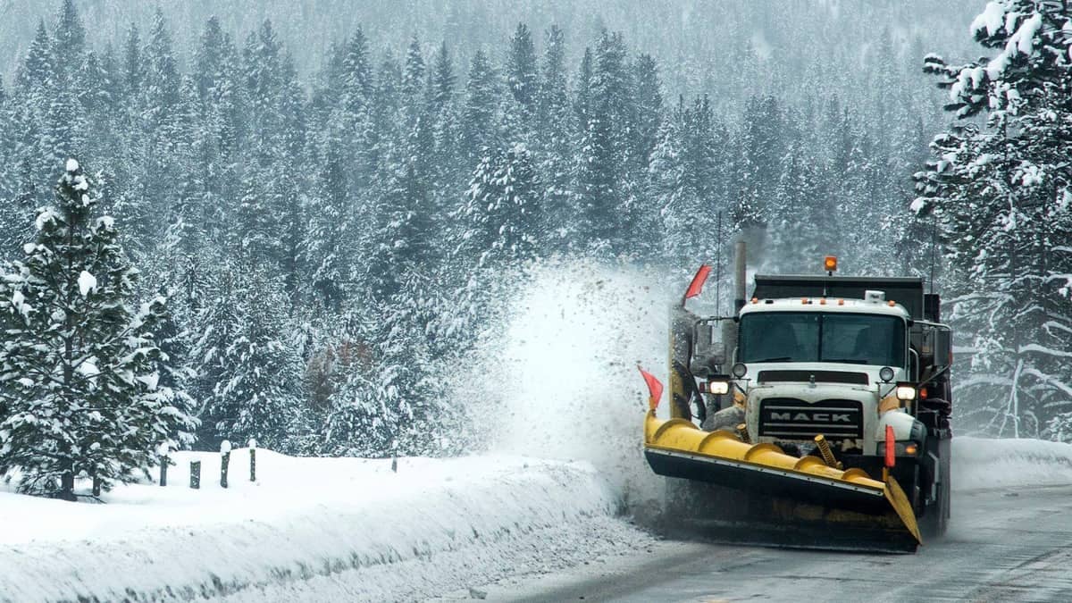 Plow truck clearing snowy Idaho highway.