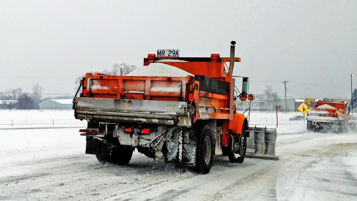 Plow trucks on a snowy Illinois highway.