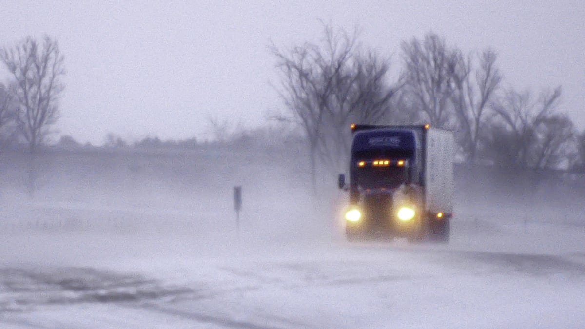 Tractor-trailer moving through a Minnesota blizzard.