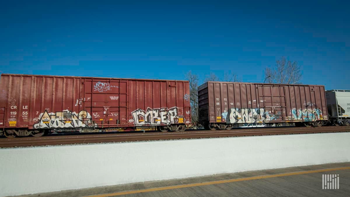 A photograph of boxcars in a rail yard.