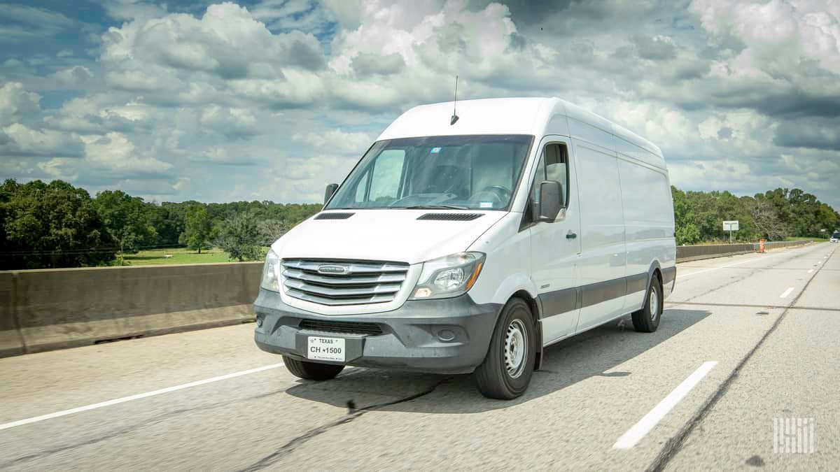 A photograph of a van driving on a road.