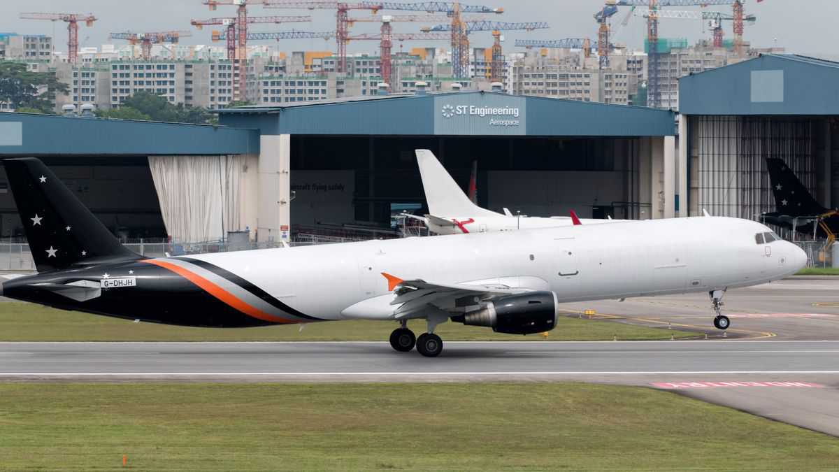 A white plane with a dark blue takes off.