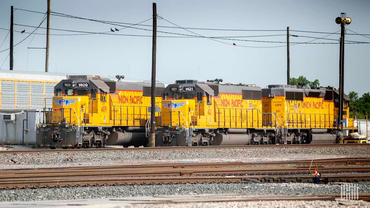 A photograph of three Union Pacific locomotives in a rail yard.