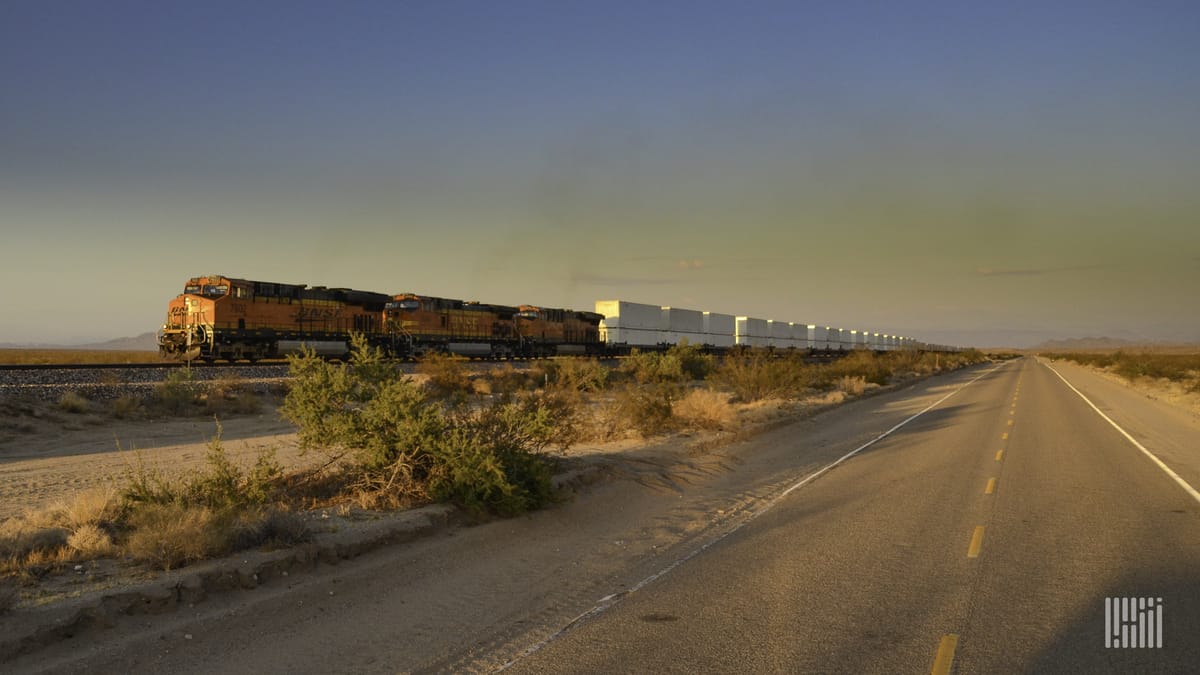 A photograph of a BNSF train hauling intermodal containers across a field.